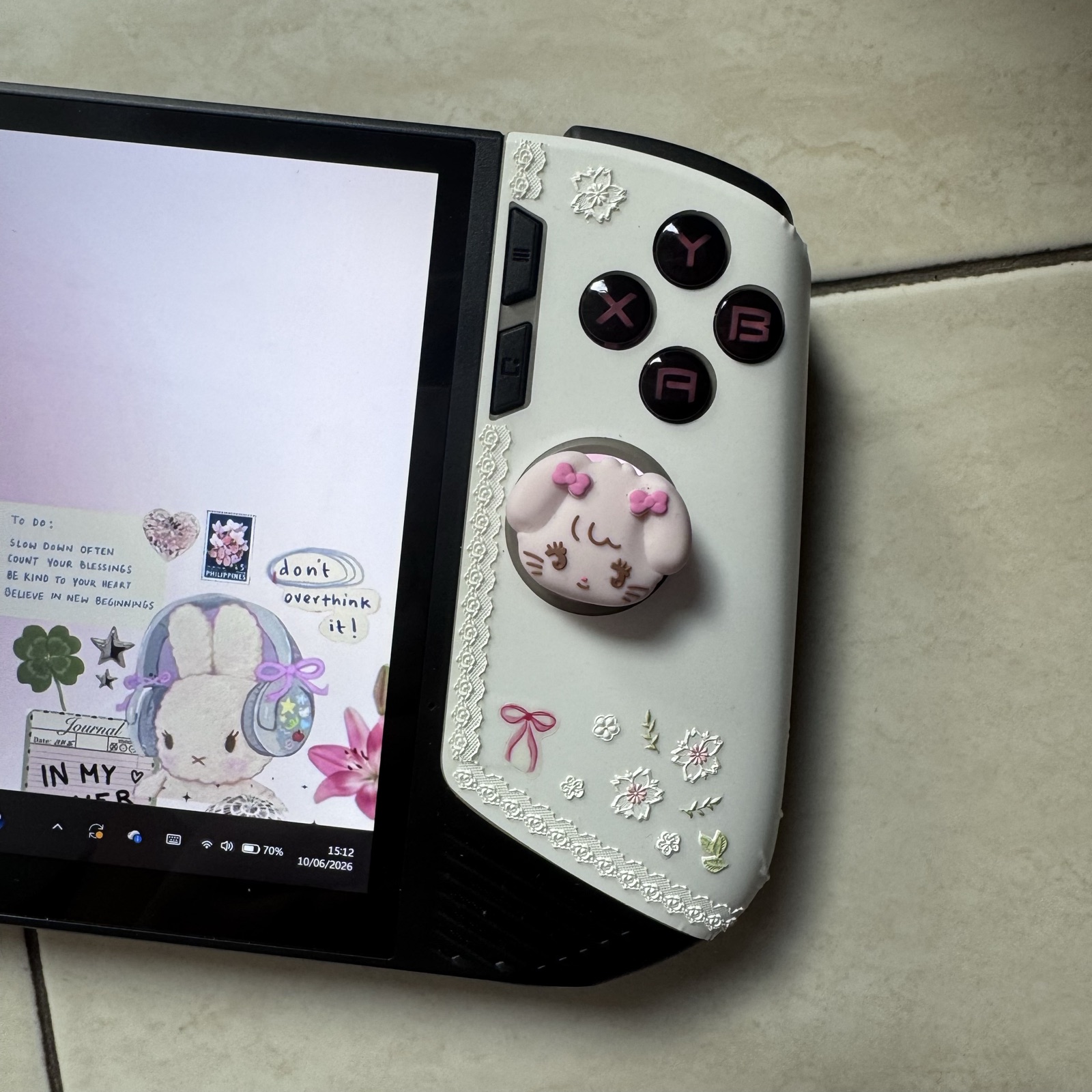 Close on the right grip — lace trim, a tiny bow, and a cat with pink ears.